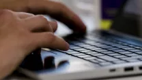 Hands typing on a laptop