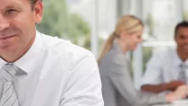 People in an office with a man smiling at the camera