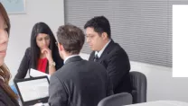 Close up of a woman with a team meeting in the background