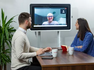 Colleagues in huddle meeting with video conferencing