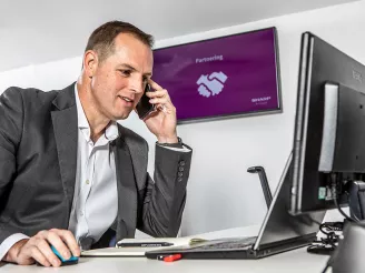 Man at desk with laptop and phone