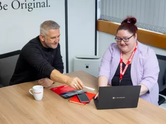 Man and woman sat at laptop on online ordering portal