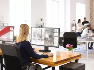 A woman working on a desktop display in an office