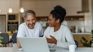 Two people sat at a laptop - discussing cyber security 