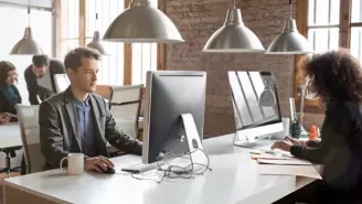 Team working in an office on desktop displays