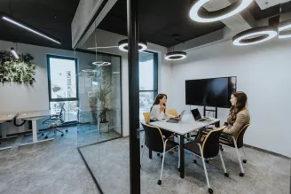 Young business women discussing in cubicle at the office