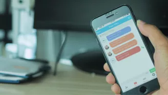 Person holding phone whilst on hot desking app