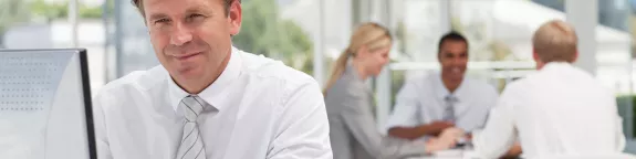 People in an office with a man smiling at the camera