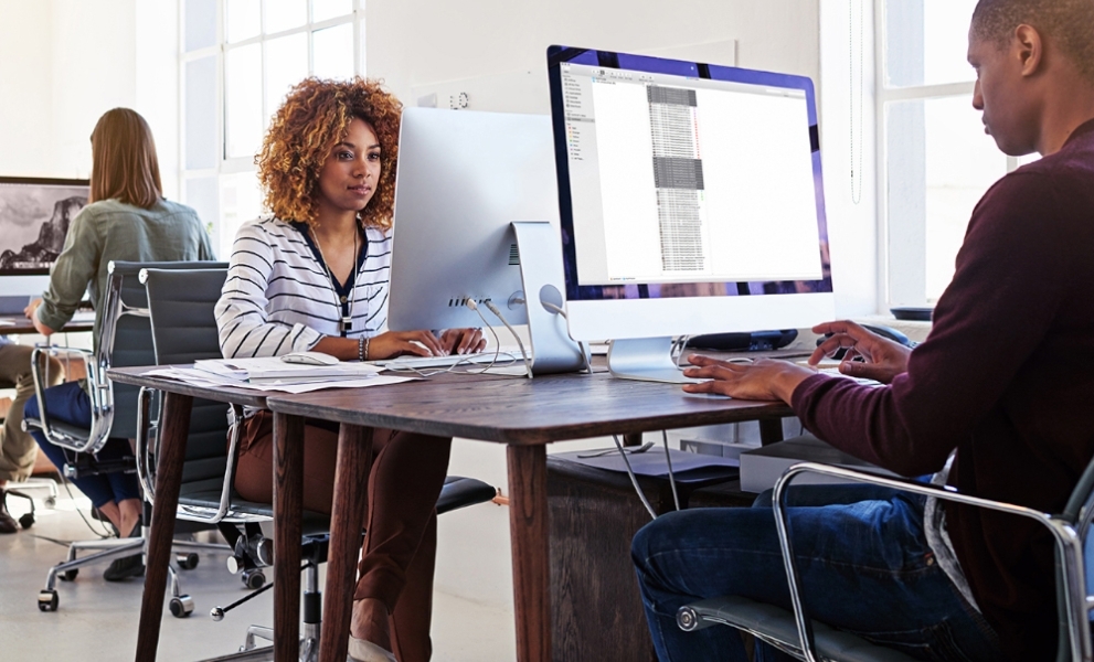 Three office workers working at desks 