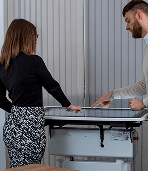 Interactive touchscreen table with two people collaborating