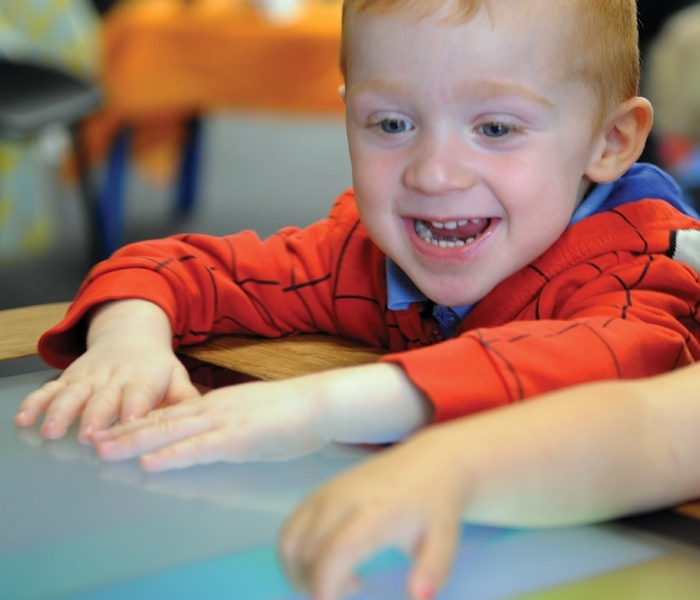 A child using Sharp's Interactive Touchscreen Table