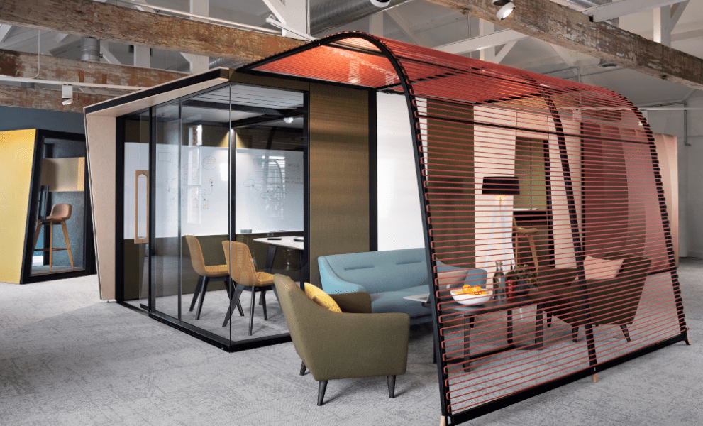 Modern meeting room pod in open plan office with sofas, table and comfy chairs