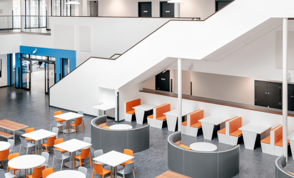 Office breakout space with orange, grey and white canteen furniture and huddle space furniture