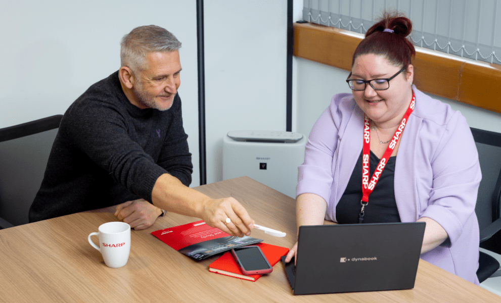 Man and woman sat at laptop on online ordering portal