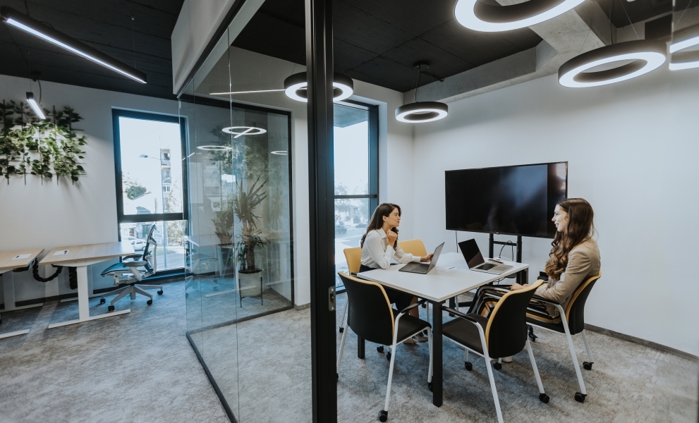 Young business women discussing in cubicle at the office