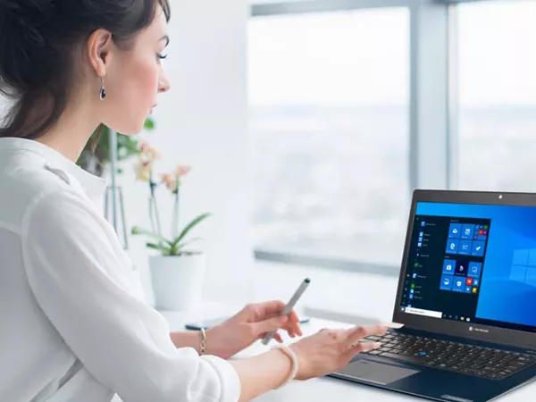 Business laptop being used by a woman in a white shirt